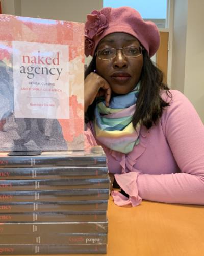 Naminata Diabate next to a stack of her published book